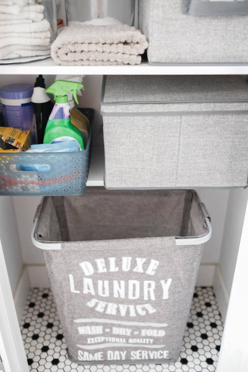 learner observer linen closet organizing bottom shelf with laundry bin