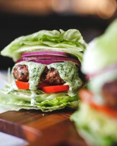 burger with topping wrapped in a lettuce leaf