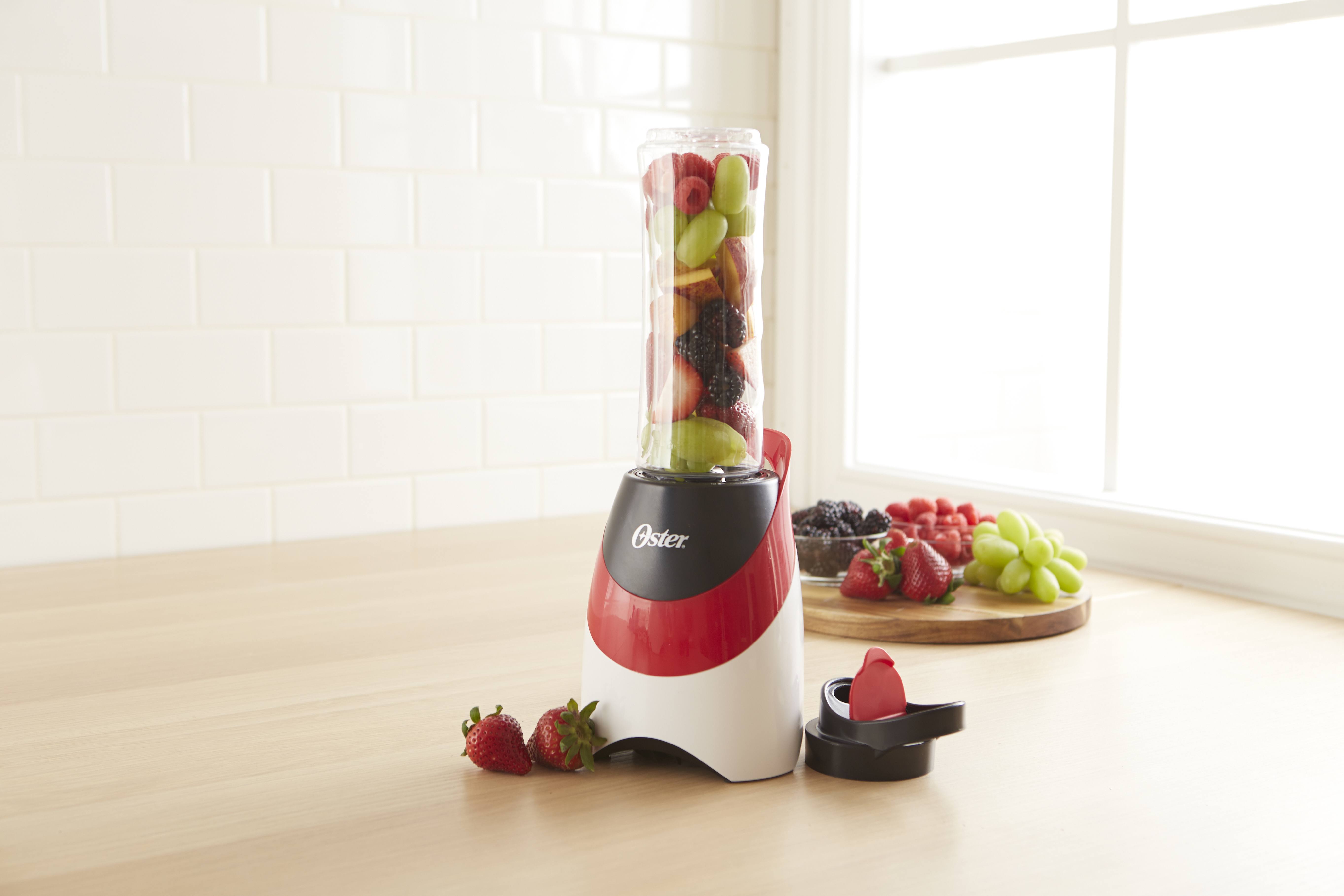 red and white personal blender with fruit