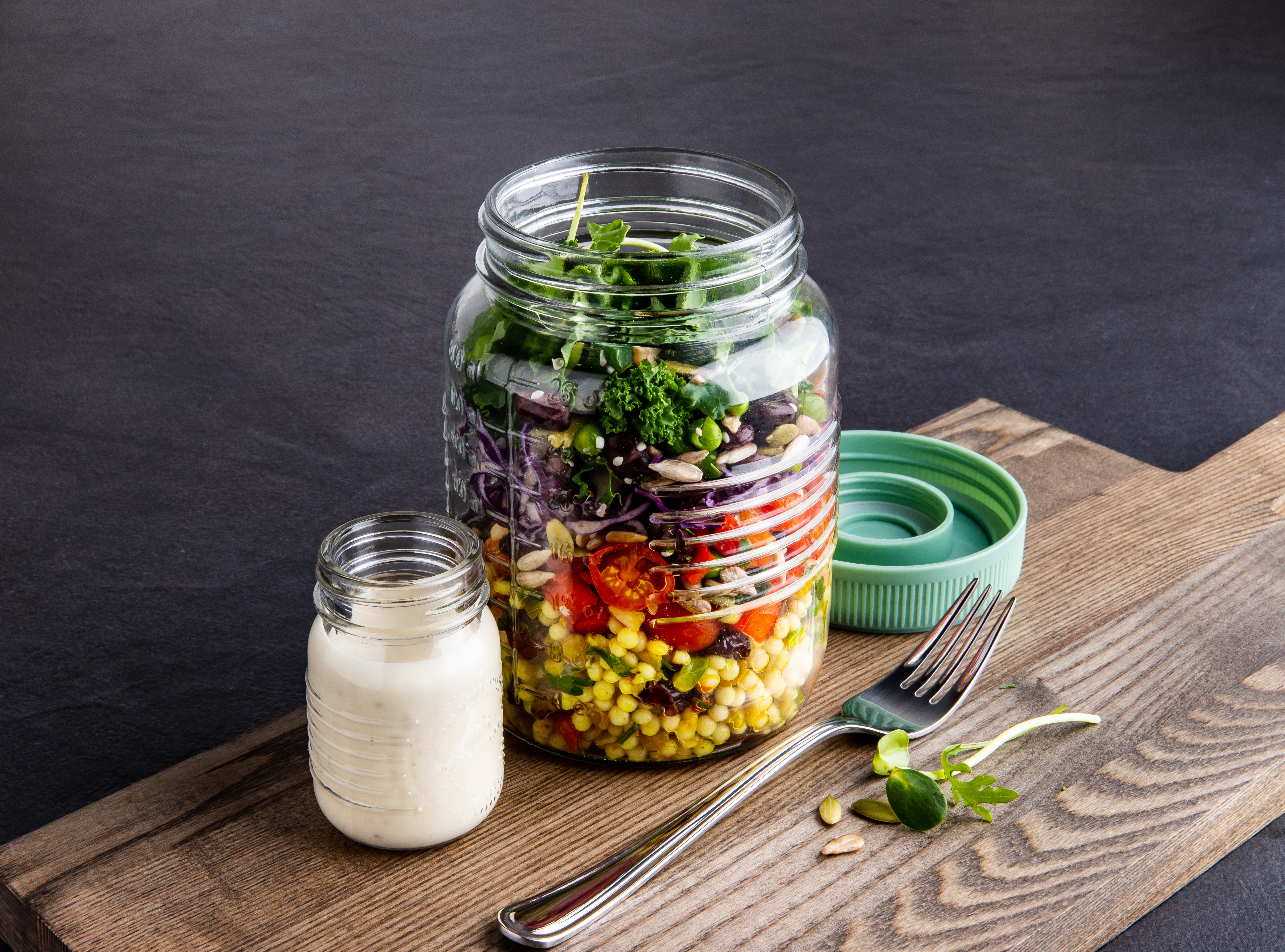 on the go glass salad mason jar with salad inside and dressing in a mini jar on the side